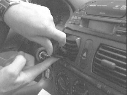 En hand justerar en del av instrumentpanelen i en Fiat Brava/Bravo.