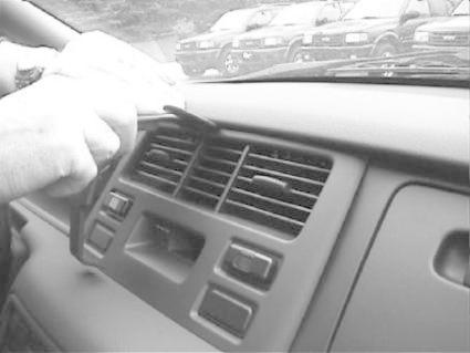 En hand justerar luftventiler i en bilinteriör.