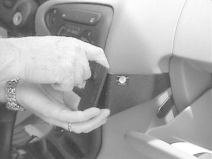 En hand installerar en komponent i instrumentpanelen på en Hyundai Elantra 96-00.