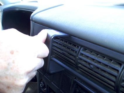En hand greppar en ventilationsgrill i en Volkswagen Caravelle.