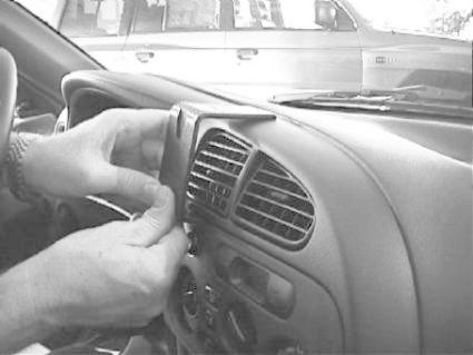 En person installerar en monteringsbygel i en bil.