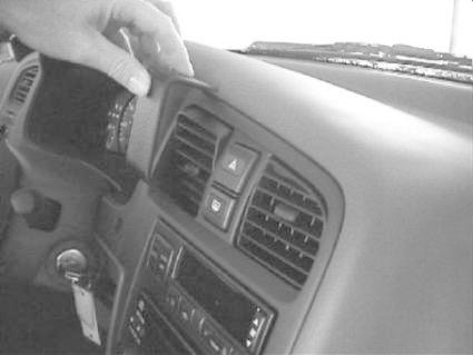 En hand pekar på bilens dashboard och luftventiler i en Nissan Primera.