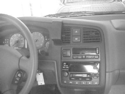 Bilden visar instrumentbrädan i en Nissan Primera 96-99 med stereo och kontrollpanel.