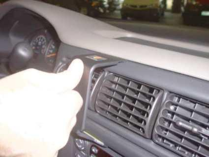 En hand visar en del av instrumentbrädan i en Chevrolet Trans Sport/Venture.