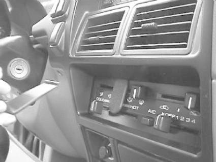 En bilinteriör med kontroller för luftkonditionering och radio.