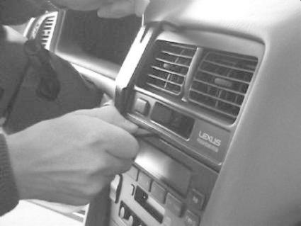 En hand arbetar med kontrollpanelen i en Lexus ES, modell 97-01.