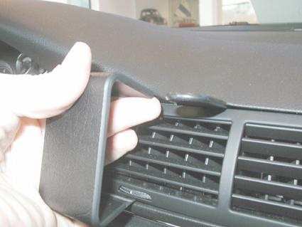 Del av instrumentpanel med en hand som håller en detaljerad del.