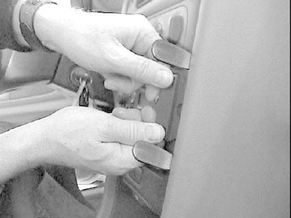 Två händer justerar en del i en bilinteriör.