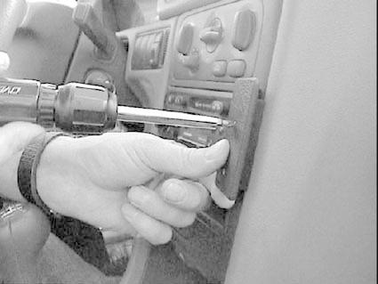 En hand använder en skruvmejsel på instrumentpanelen i en Volvo.