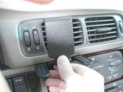 En hand sätter fast en del på bilens luftventil.