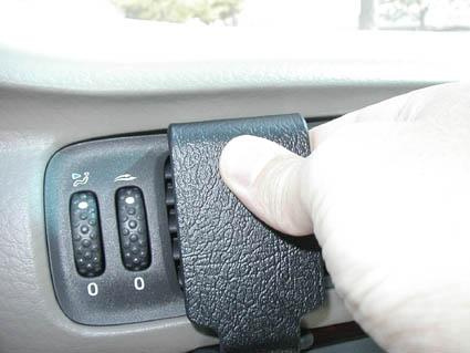 Hand som trycker på en knapp på instrumentpanelen i en Volvo.