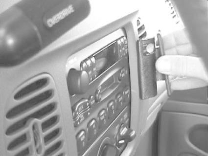 En hand håller i en verktyg för att justera något på instrumentpanelen.