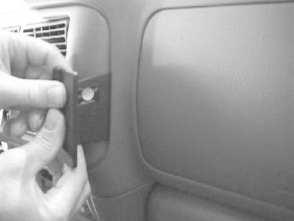 En hand fäster en del på en bils interiör, troligtvis för Mitsubishi Pajero Sport.