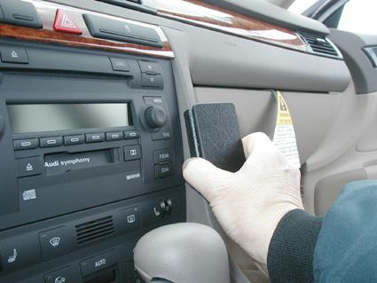 En hand som hållar en svart regel, inuti en Audi A6 från 98-03.