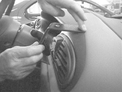 En hand justerar en del av instrumentbrädan i en Chrysler Voyager.