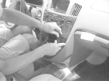 Hand som monterar en bilkomponent i en Lexus RX interiör.