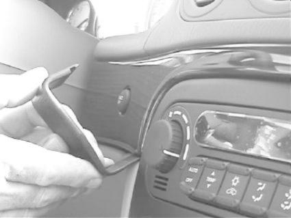 Hand som använder verktyg för att pilla bort panel i Chrysler 300M.