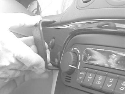 En hand justerar en kontrollpanel i en Chrysler 300M.