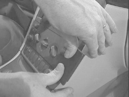 Händer som installerar eller justerar en bilpanel i Volvo S80.