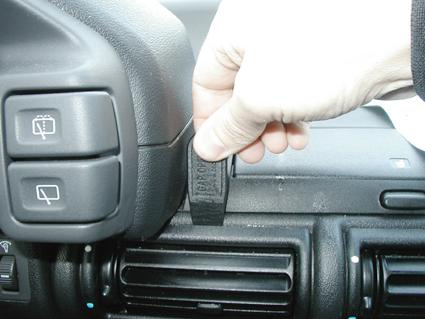 En hand drar i en svart knapp på instrumentpanelen.