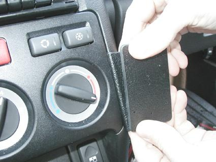 En hand visar en svart platta som monteras på en instrumentpanel.