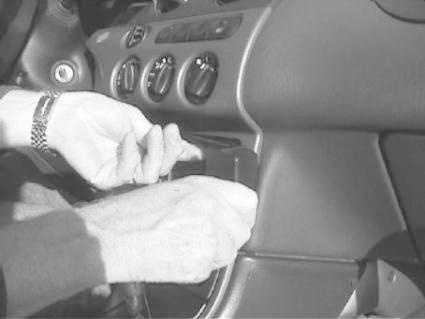 En person installerar en monteringsbygel i en bil.