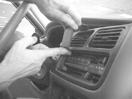 En hand installerar något på instrumentpanelen i en Chevrolet Tracker.