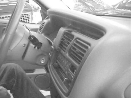 Bilden visar instrumentbrädan och mittkonsolen i en Chevrolet Tracker 98-04.