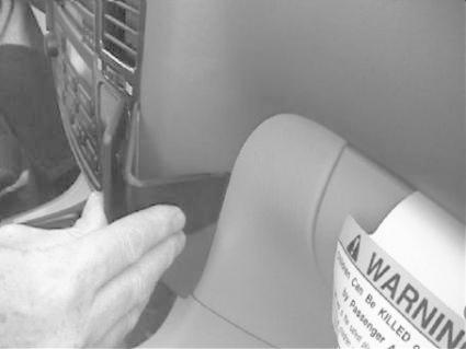 En hand justerar en väggpanel i en bilinteriör.