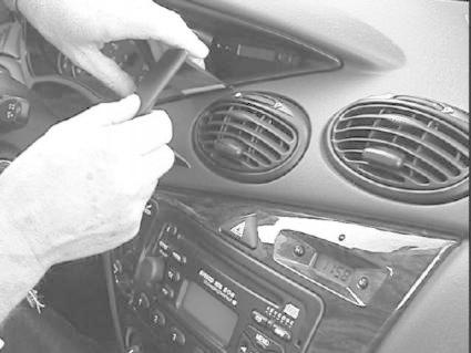 En person arbetar med instrumentpanelen på en Ford Focus 99-04.