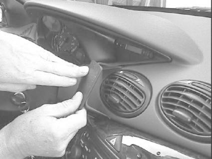 Två händer som arbetar med ett element i en Ford Focus interiör.