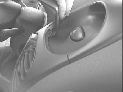 Centrerad kontrollpanel i en Peugeot 206, med en hand som interagerar med instrumenten.