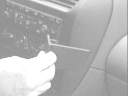 Monteringsbygel för bilradio, handhållen och vinklad.