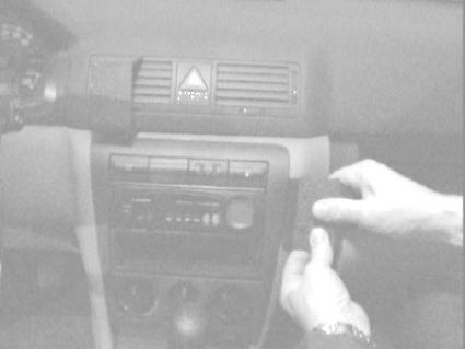 Bild av en bilinteriör med fokus på kontrollpanelen och hand som justerar en del.