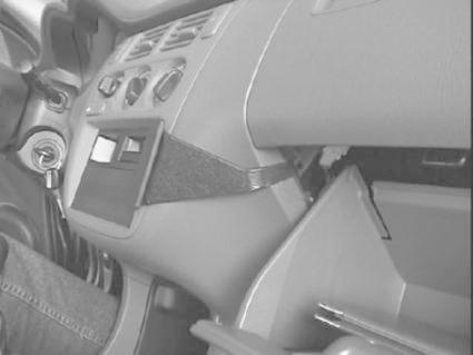 Monteringsbygel i bilens interiör nära förarsidan och handskfacket.