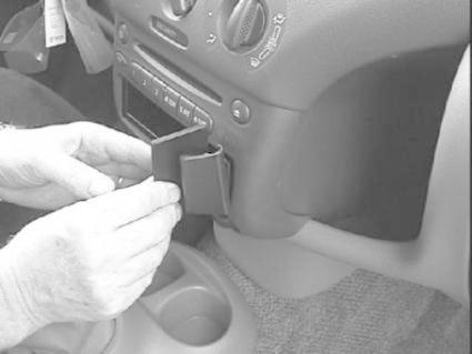 En person installerar en monteringsbygel i en bil.