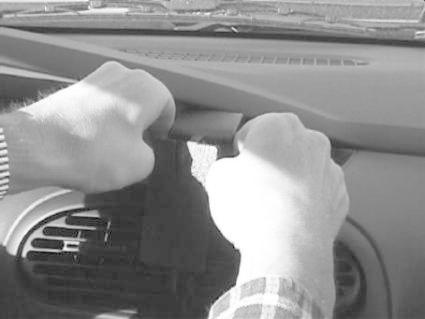 En person installerar en monteringsbygel i en bil.