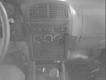 Bilinteriör med monteringsbygel för Kia Sportage, kontroller och vagnskontroll synliga.