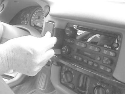 Hand som justerar stereoenhet i Chevrolet Impala 00-05.