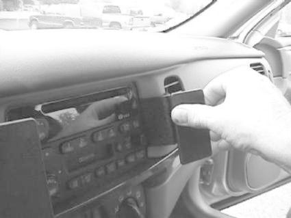 En hand som justerar radion i en Chevrolet Impala 00-05.