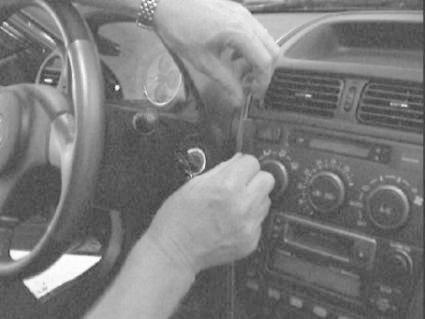 En hand justerar kontrollpanelen i en Lexus IS 01-05.