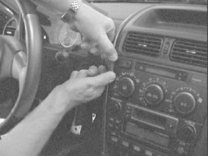 En person arbetar med instrumentpanelen i en Lexus IS 01-05.