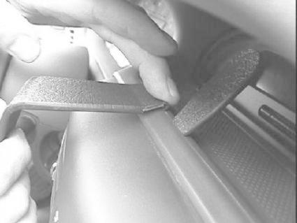 En hand som använder ett verktyg på insidan av en bil.