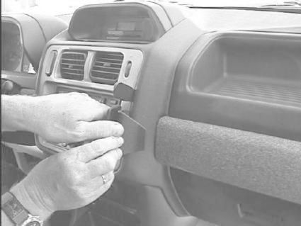 En person installerar en monteringsbygel i en bilinteriör.