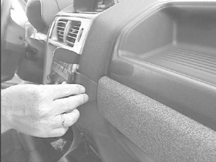 En hand fäster en monteringsbygel på insidan av en bil.