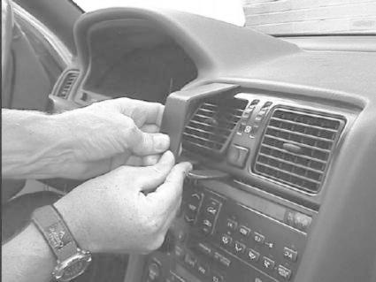 En person installerar en monteringsbygel på en bils instrumentbräda.