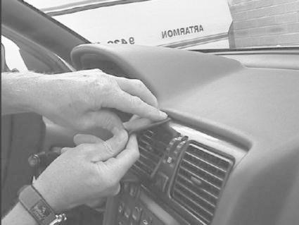 En person fäster en monteringsbygel på en bils instrumentbräda.