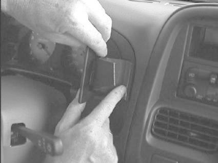 En hand installerar en enhet i bilen, Nissan Navara 00-05.