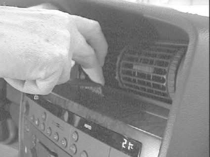 En hand som justerar något vid luftventilen i en Opel Omega.