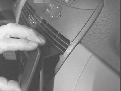 En hand fäster en monteringsbygel på bilens instrumentpanel.